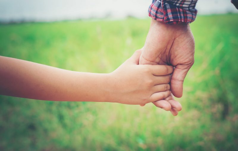 Close up of father holding his daughter hand, so sweet,family time.